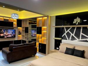 馬尼拉的住宿－Escape 1BR One Uptown BGC w/ Sound System，一间卧室配有一张床、一张沙发和一台电视。