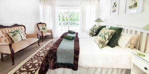 a bedroom with a bed and a couch and a window at Die Kasteel, Belvidere Estate in Knysna