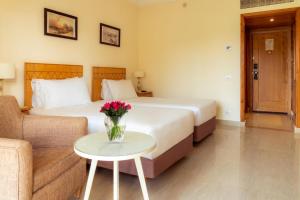 een hotelkamer met een bed en een vaas met bloemen op een tafel bij Sierra Sharm El Sheikh in Sharm El Sheikh