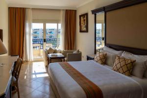a hotel room with a large bed and a living room at Grand Oasis Resort in Sharm El Sheikh