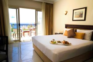 Una habitación de hotel con una cama con una bandeja de comida. en Grand Oasis Resort, en Sharm El Sheikh