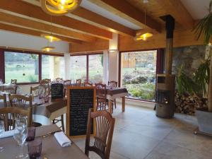 un restaurante con mesas y sillas y una chimenea en La Neyrette, en Saint-Disdier-en-Dévoluy