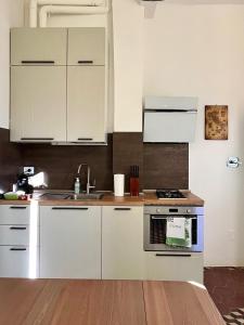 een keuken met witte kasten en een fornuis met oven bij Appartamento Mascarella 19 in Bologna
