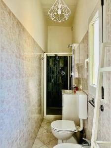 een badkamer met een toilet, een wastafel en een douche bij Appartamento Mascarella 19 in Bologna