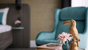 a toy bird sitting on a table with a flower at Van der Valk Hotel Brussels Airport in Diegem
