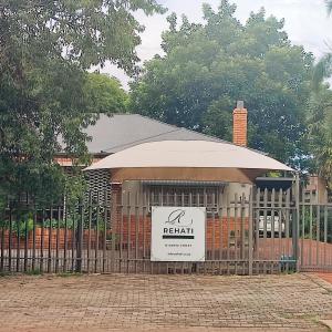 a gate with a sign in front of a building at Rehati Guesthouse in Potchefstroom