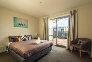 a bedroom with a bed and a sliding glass door at Josephine's Lakeside Star in Lake Tekapo