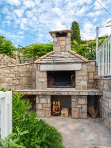 an outdoor oven with a stone wall at Holiday Home Lea in Maslinica