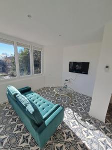 a living room with a blue couch and a flat screen tv at La Petite Maison des Boettes in Carpentras