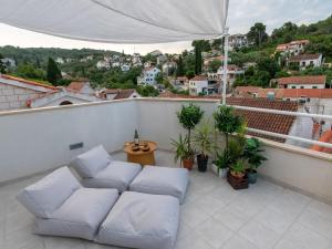 a balcony with white couches and a view of a city at Holiday Home Lea in Maslinica