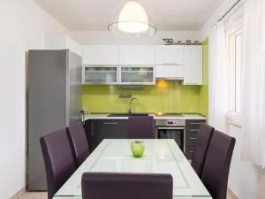 a kitchen with a table and purple chairs at Villa Jelena in Dračevica