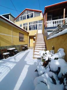 un patio cubierto de nieve con escaleras y un edificio en Bujtina Vasili, en Korçë