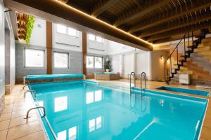 une grande piscine avec de l'eau bleue dans un immeuble dans l'établissement Willa Widokowa Wojnar, à Zakopane