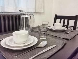 a table with plates and dishes and a glass pitcher at Cosy apartement in Antwerp's hipster neighbourhood in Antwerp