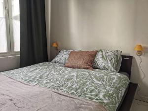 a bedroom with a bed with a green and white comforter at Cosy apartement in Antwerp's hipster neighbourhood in Antwerp