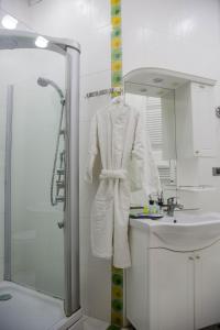 Baño blanco con lavabo y espejo en Solo Hotel, en Baku