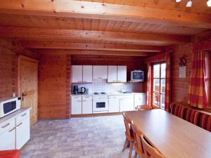 een keuken met witte kasten en een houten tafel bij Cosy holiday home near ski area in Wagrain