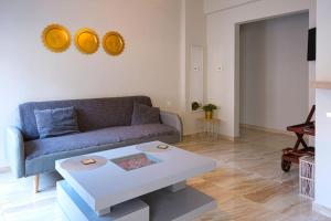 NGsuite cityspot Volos في فولوس: غرفة معيشة مع أريكة وطاولة قهوة