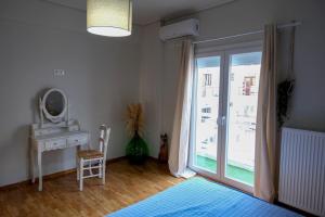 NGsuite cityspot Volos في فولوس: غرفة نوم مع نافذة وطاولة ومرآة