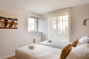 ein Schlafzimmer mit zwei Betten und einem Fenster in der Unterkunft Villa l'Indépendante - Proche de la plage in Dinard