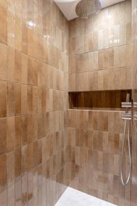 ein gefliestes Badezimmer mit einer Dusche mit Schlauch in der Unterkunft Villa l'Indépendante - Proche de la plage in Dinard