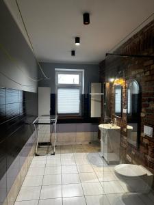 a bathroom with a glass shower and a brick wall at Pokoje Dworcowa 10 in Lubawa