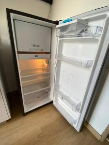 an empty refrigerator with its door open in a kitchen at Apartaestudio Bogotá Colombia in Bogotá