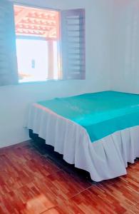 uma cama num quarto azul com uma janela em Dunas Mar em Guajiru em Trairi