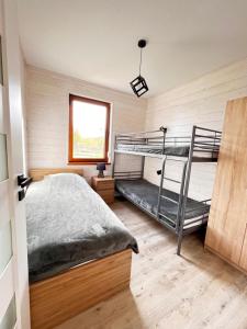 a bedroom with two bunk beds and a window at Na Stoku Żukowa in Ustrzyki Dolne