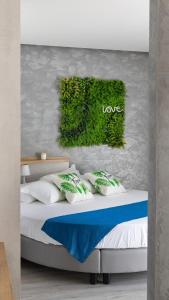 1 dormitorio con 1 cama con pared verde en Hotel Majorca, en Gabicce Mare