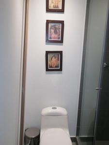 baño con aseo y 3 cuadros en la pared en Apartaestudio Bogotá Colombia, en Bogotá
