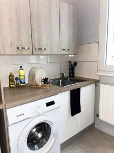 a kitchen with a sink and a washing machine at Le Bonheur, Limite Grenoble, Proche Tram in Seyssinet-Pariset