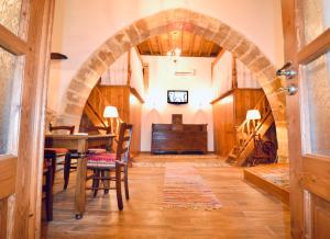 アルハンゲロスにあるVilla Patitiri Traditional Houseのアーチ道のあるダイニングルーム(テーブル、椅子付)
