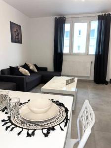 a living room with a couch and a table with a plate on it at Le Bonheur, Limite Grenoble, Proche Tram in Seyssinet-Pariset