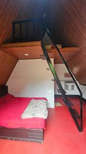 a bedroom with a bunk bed with a red floor at Vattavada Jungle Resort in Munnar