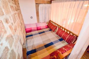 a bed with colorful pillows on it in a room at Villa Patitiri Traditional House in Archangelos