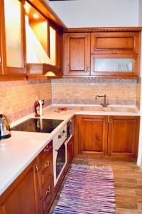 a kitchen with wooden cabinets and a sink at Villa Patitiri Traditional House in Archangelos