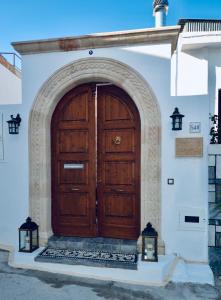 a wooden door on a white building with two lights at Villa Patitiri Traditional House in Archangelos