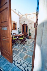 an open door to a patio with a table and chairs at Villa Patitiri Traditional House with hot tub in Archangelos