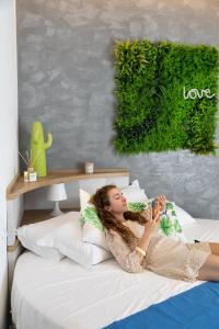 a woman laying on a bed talking on a phone at Hotel Majorca in Gabicce Mare