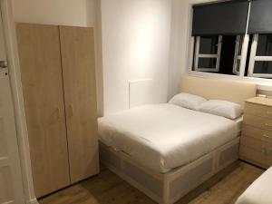 a small bedroom with a bed and a window at Lovely 3 bedroom North london in London