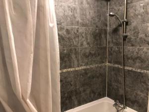 a shower with a white shower curtain and a tub at Lovely 3 bedroom North london in London