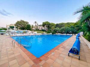 una gran piscina azul con sillas y sombrillas en La Manga Club 2 Bed Apartment Great location, en Murcia