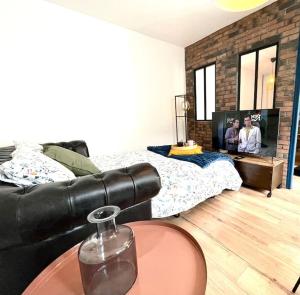 Magnifique Appartement Hypercentre - Le Charly في بو: غرفة معيشة مع أريكة جلدية سوداء وتلفزيون