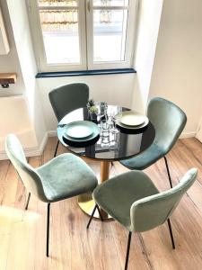 a dining room with a table and green chairs at Magnifique Appartement Hypercentre - Le Charly in Pau