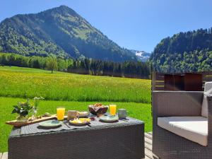 una mesa con comida y vistas a la montaña en Appartements Moosbrugger Haus Herlinde en Schoppernau