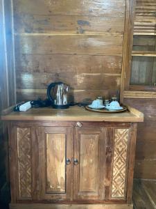 a wooden cabinet with a tea kettle on top of it at Black Lava Hostel and Lodge in Kintamani