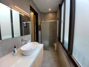 ein Badezimmer mit einem weißen Waschbecken und einer Dusche in der Unterkunft Spatious luxe apartment Paseo de Gracia Diagonal in Barcelona