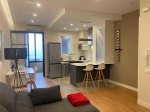 eine Küche und ein Wohnzimmer mit einem Sofa und einem Tisch in der Unterkunft Spatious luxe apartment Paseo de Gracia Diagonal in Barcelona