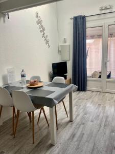 uma mesa de jantar e cadeiras numa sala de estar em Appartement duplex lumineux idéalement situé em Arès